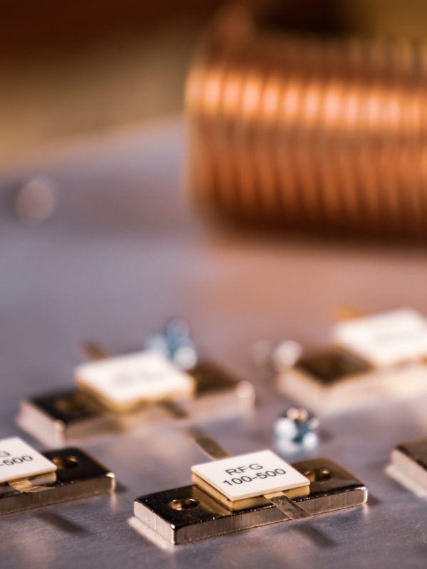 Close-up of five metal plates on a large iron case against a blurred twisted copper wire background. Concept of production of super powerful computer equipment for multifunctional centers